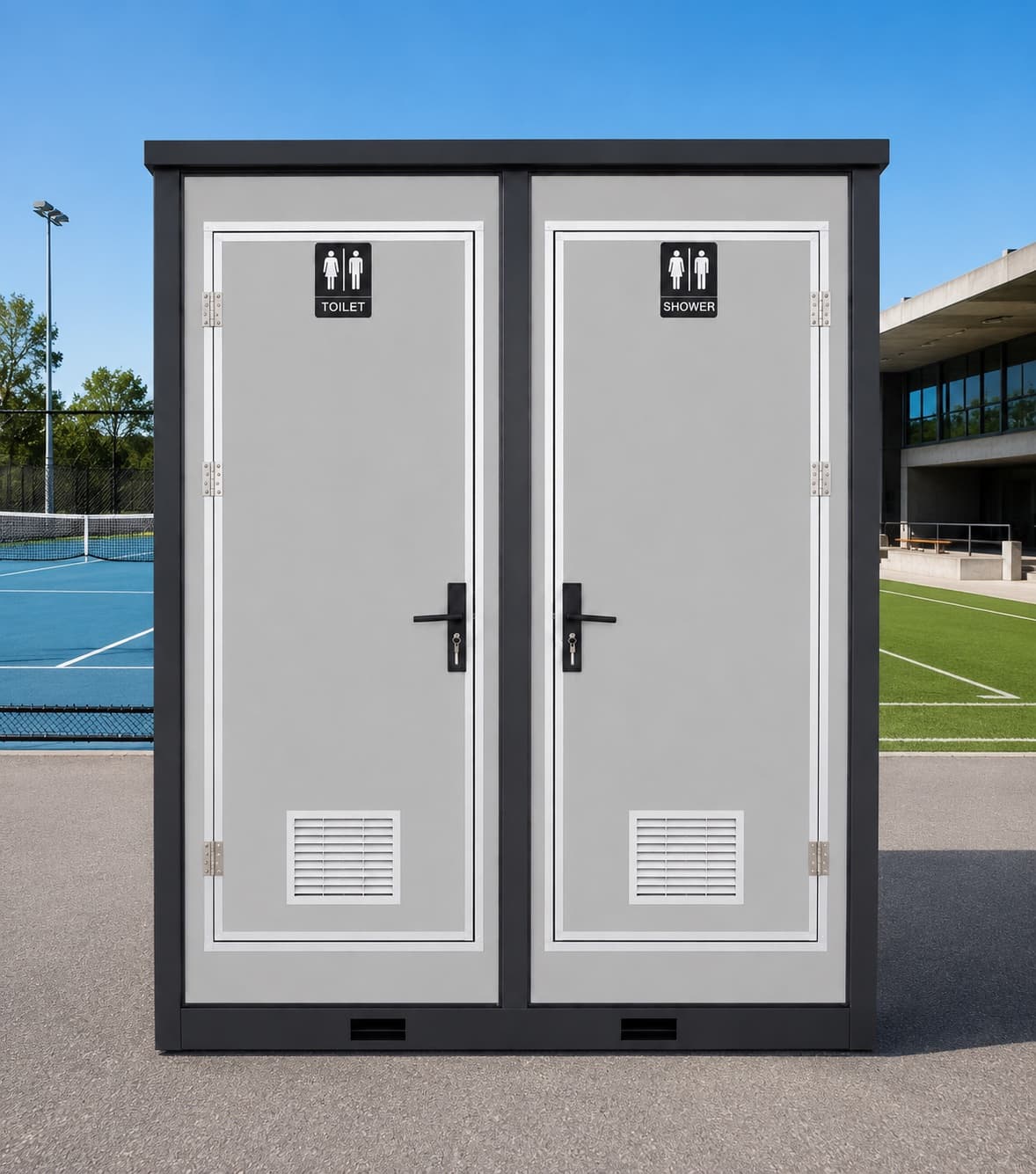 NOVAMOD Club Bathroom at a sports facility — frontal view showing toilet and shower doors with athletic complex in background